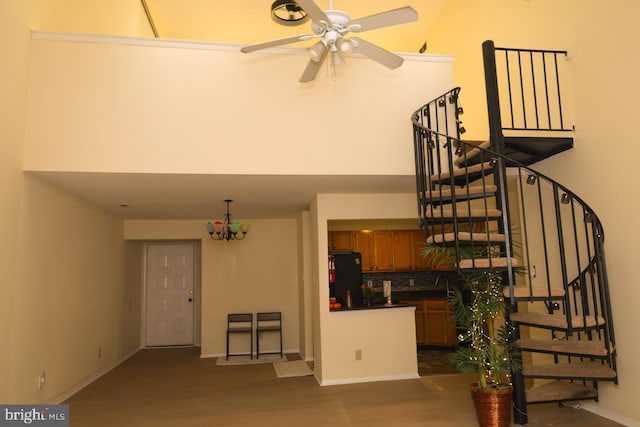 staircase with a ceiling fan, baseboards, and wood finished floors