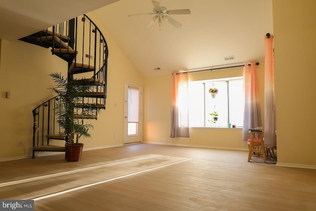 unfurnished living room featuring wood finished floors, ceiling fan, stairway, high vaulted ceiling, and baseboards