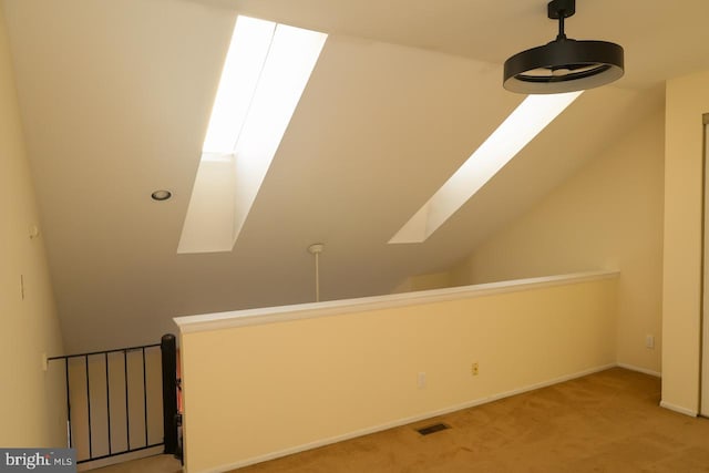 bonus room featuring light carpet, a skylight, vaulted ceiling, and baseboards