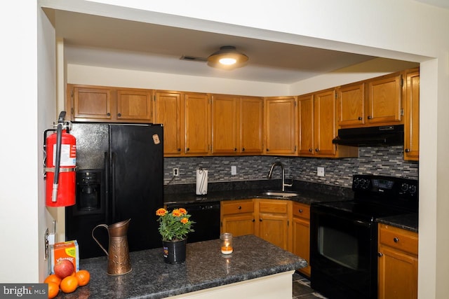 kitchen featuring under cabinet range hood, black appliances, a sink, and backsplash
