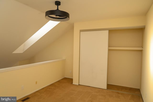 bonus room with light colored carpet, a skylight, lofted ceiling, and baseboards