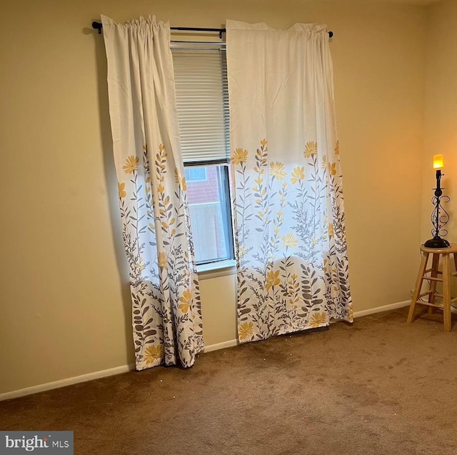 unfurnished room featuring carpet and baseboards
