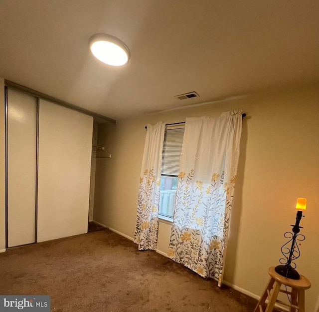 unfurnished bedroom featuring carpet, a closet, and baseboards