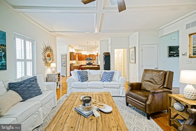 living area with visible vents, wood finished floors, beam ceiling, ceiling fan, and coffered ceiling