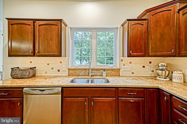 kitchen featuring a sink, stainless steel dishwasher, backsplash, and light stone countertops