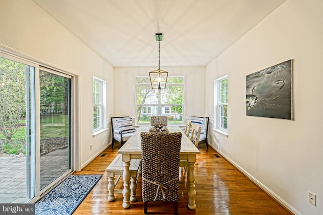 dining area featuring baseboards, wood finished floors, and visible vents