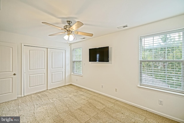 unfurnished bedroom featuring carpet flooring, a ceiling fan, baseboards, visible vents, and a closet