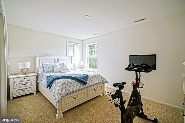 bedroom with baseboards, light colored carpet, and visible vents