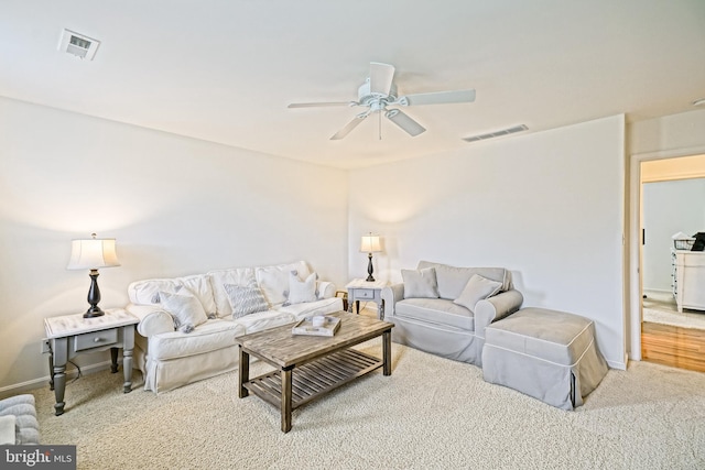 living area with ceiling fan, visible vents, baseboards, and carpet