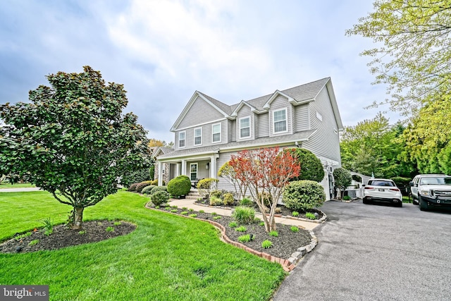 view of front of property featuring a front lawn and aphalt driveway