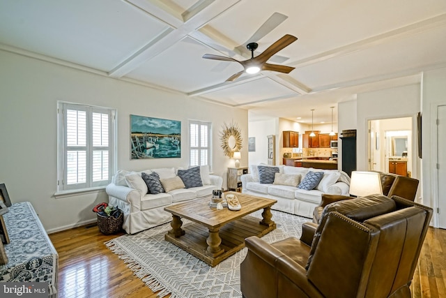 living room with wood-type flooring, a ceiling fan, coffered ceiling, and beamed ceiling