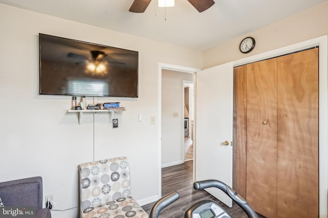 living area with baseboards, wood finished floors, and a ceiling fan