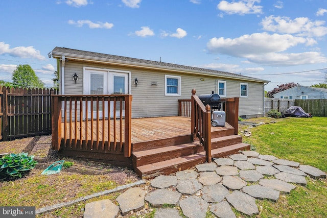 back of house featuring a lawn, a deck, and a fenced backyard