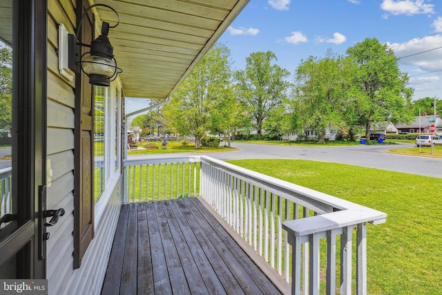 wooden deck featuring a lawn and covered porch
