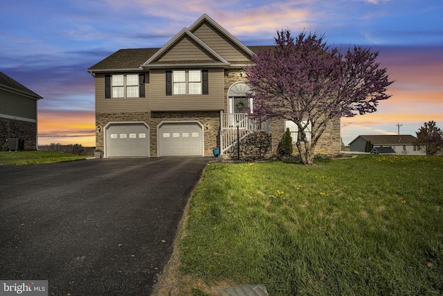 5 Raven Way, Shippensburg, PA 17257 - view of front of home with a garage, driveway, stone siding, cooling unit, and a front yard