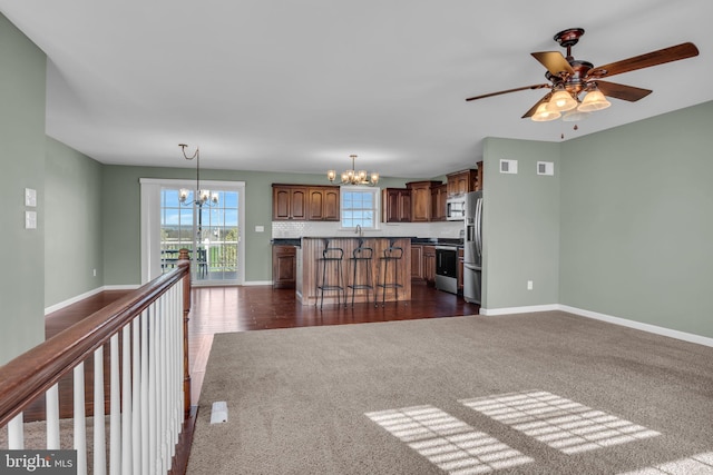 5 Raven Way, Shippensburg, PA 17257 - unfurnished living room with dark carpet, baseboards, visible vents, and ceiling fan with notable chandelier