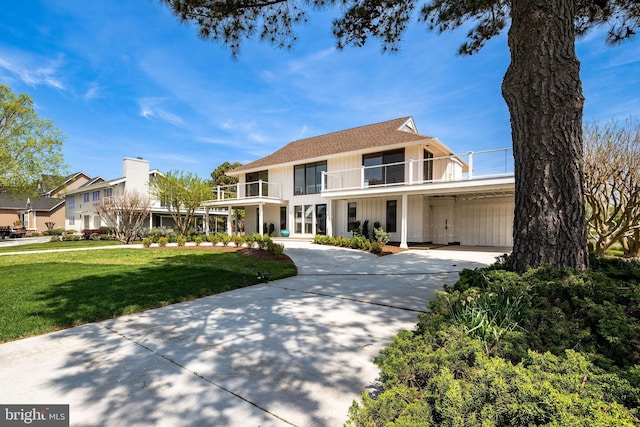 128 W Side Dr, Rehoboth Beach, DE 19971 - view of front facade featuring a balcony, driveway, and a front yard