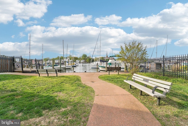 view of home's community featuring a yard, fence, and a dock