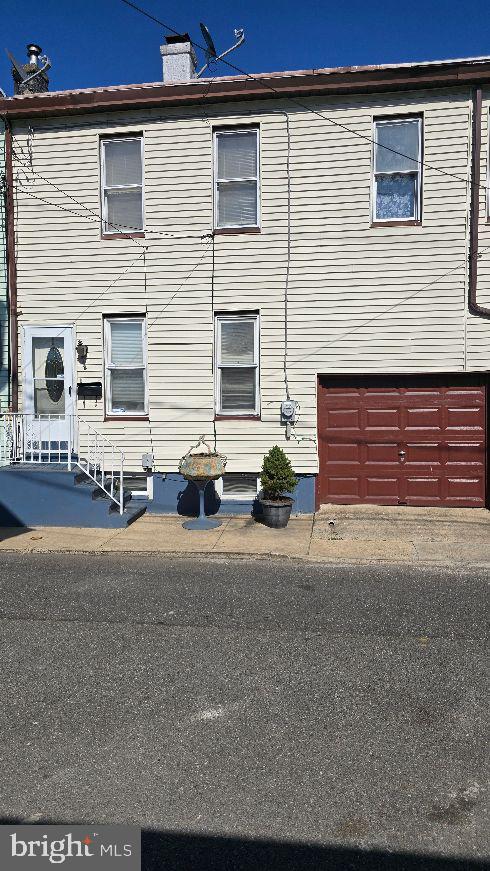 view of side of property with a chimney and an attached garage