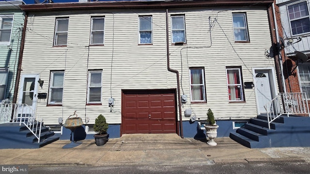 townhome / multi-family property with an attached garage and concrete driveway