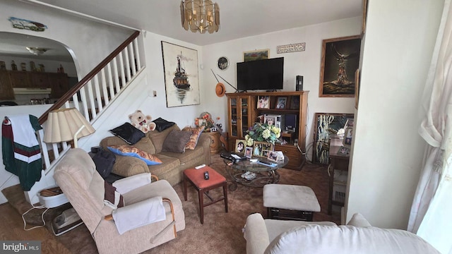 living area with a chandelier and stairs