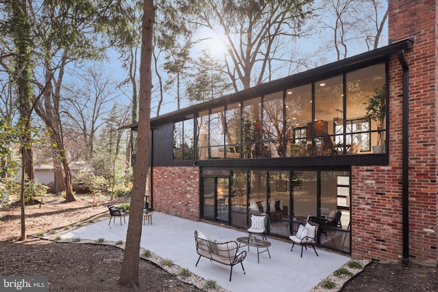 rear view of house with a patio area and brick siding