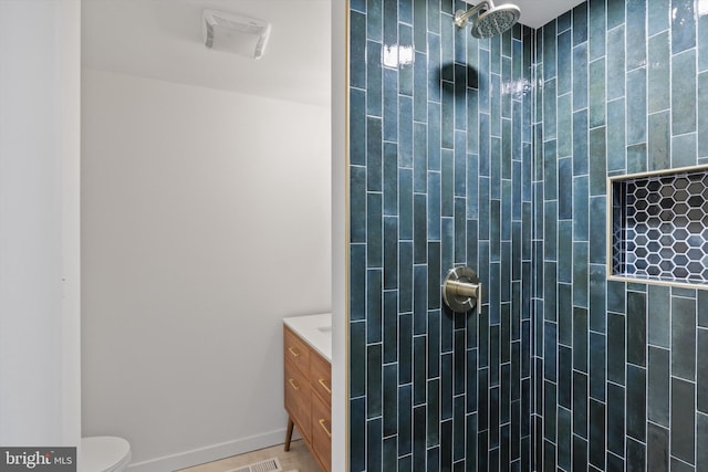 full bathroom featuring toilet, vanity, and tiled shower