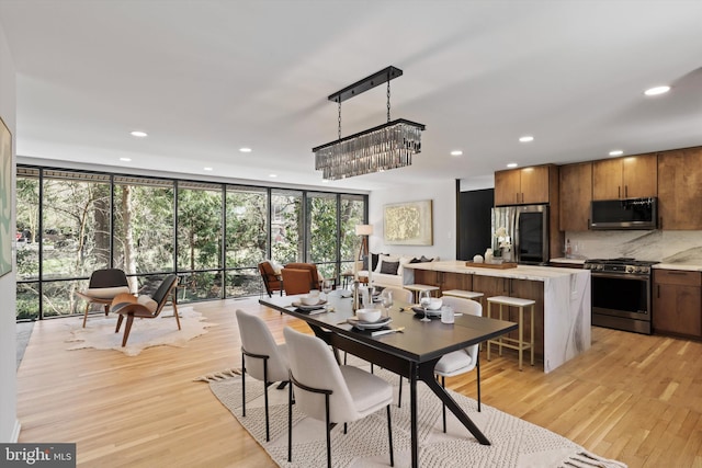 dining area with plenty of natural light, floor to ceiling windows, and recessed lighting