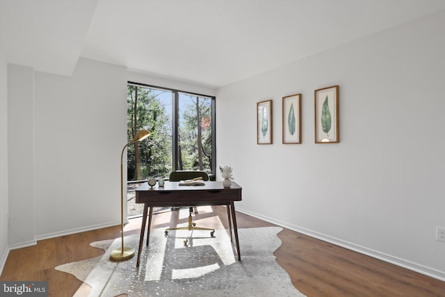 office space featuring baseboards and wood finished floors