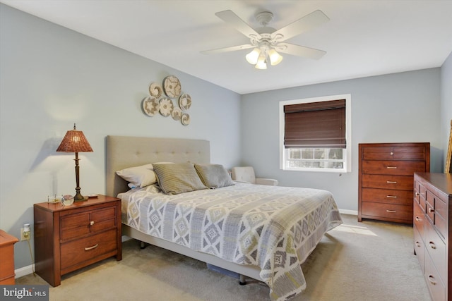 bedroom featuring ceiling fan, light carpet, and baseboards