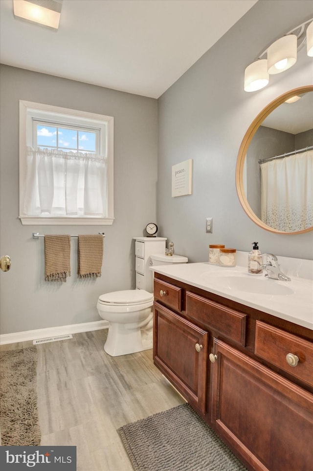 full bath featuring visible vents, baseboards, toilet, wood finished floors, and vanity