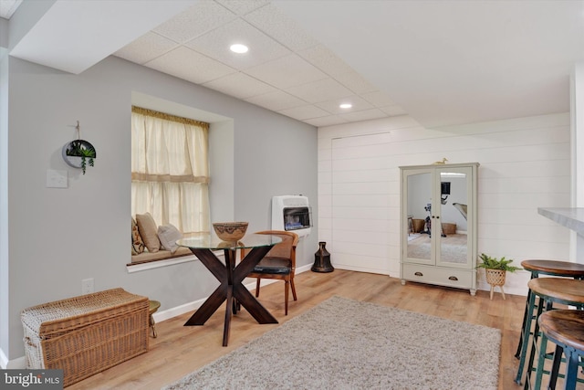 dining area featuring recessed lighting, heating unit, a drop ceiling, and wood finished floors