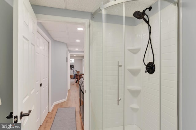 full bathroom featuring recessed lighting, wood finished floors, baseboards, a stall shower, and a paneled ceiling