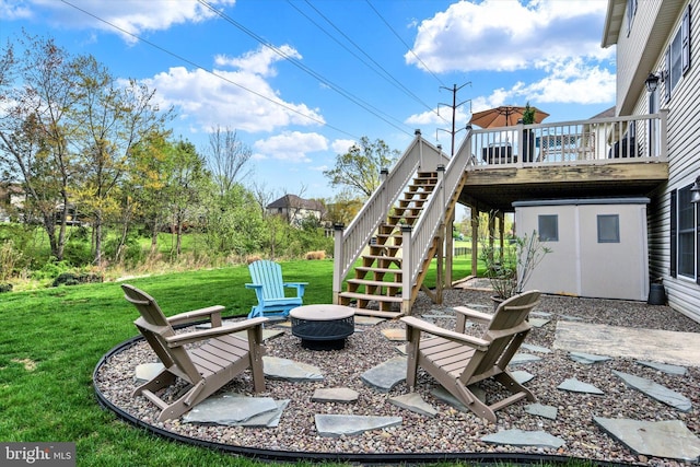view of yard with a deck, stairs, and a fire pit