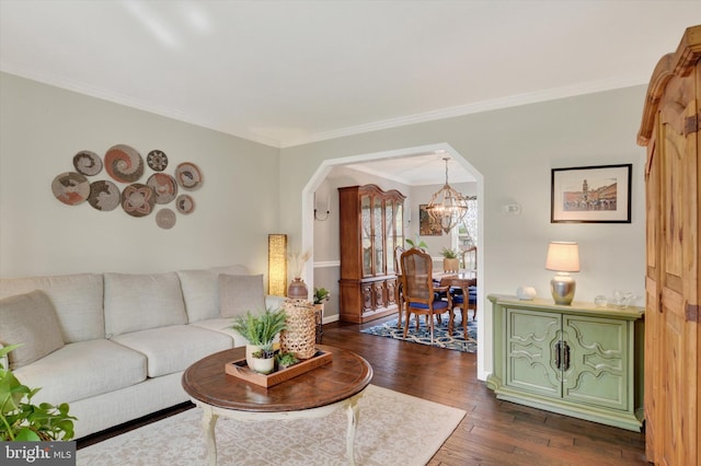 living area featuring crown molding, baseboards, an inviting chandelier, dark wood-style flooring, and arched walkways