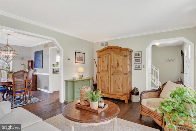 living area with a notable chandelier, dark wood-style floors, arched walkways, and visible vents
