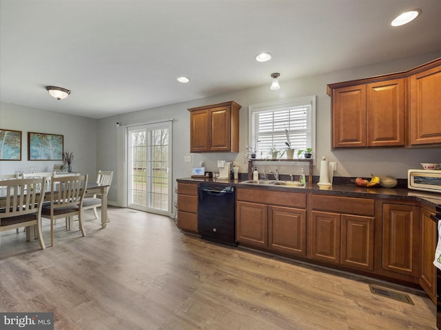 kitchen featuring a sink, dark countertops, visible vents, black dishwasher, and brown cabinets