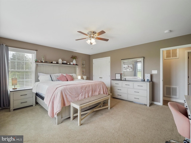 bedroom featuring visible vents, a ceiling fan, and light carpet