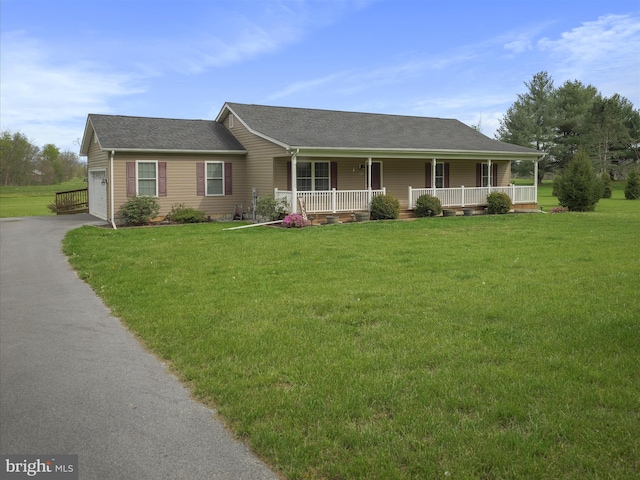 view of front of home featuring a garage, driveway, a front lawn, and covered porch