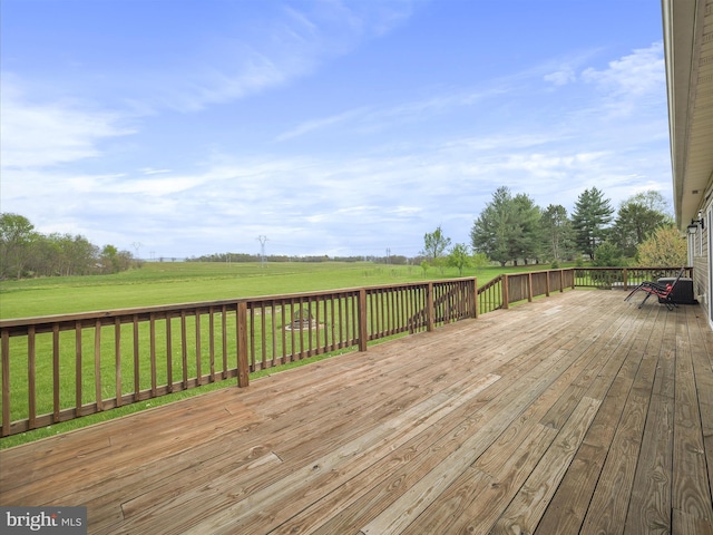 wooden terrace featuring a rural view and a yard