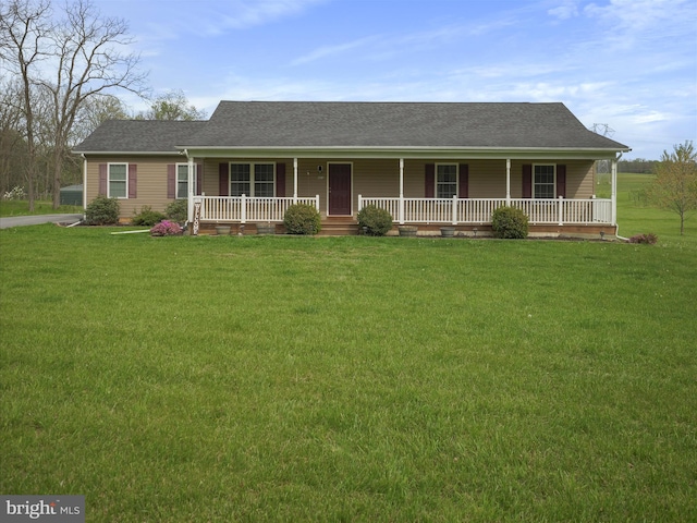 view of front of property with a front yard, covered porch, and roof with shingles