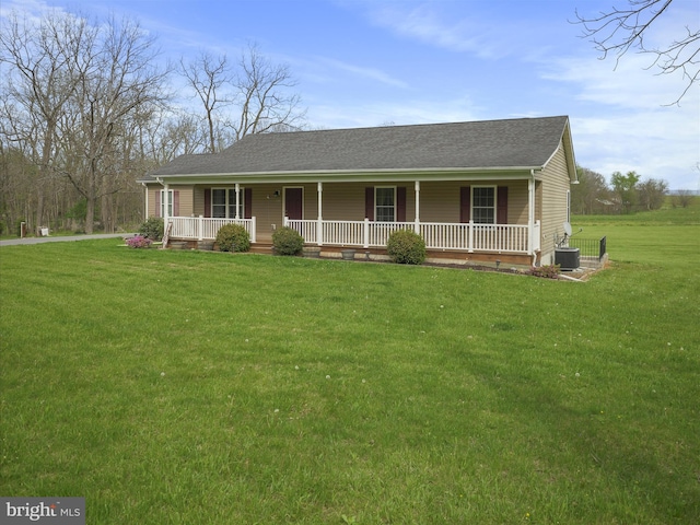 view of front facade featuring central AC, a porch, a front lawn, and a shingled roof
