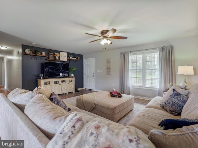 living area with wood finished floors, baseboards, and ceiling fan