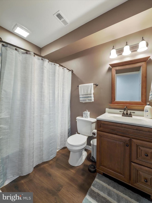 full bathroom with wood finished floors, visible vents, toilet, and vanity