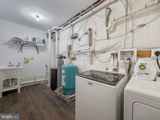 clothes washing area featuring separate washer and dryer, wood finished floors, and laundry area