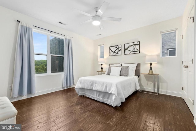 bedroom with visible vents, baseboards, ceiling fan, and dark wood-style floors