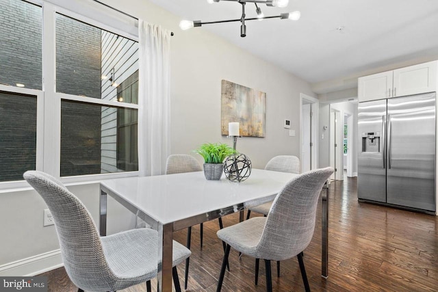 dining room with an inviting chandelier, baseboards, and wood finished floors