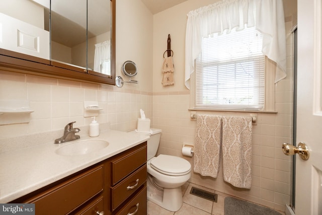 full bathroom with visible vents, tile patterned flooring, vanity, toilet, and a shower with door