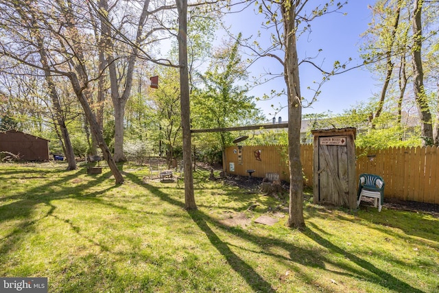 view of yard with fence and an outdoor structure