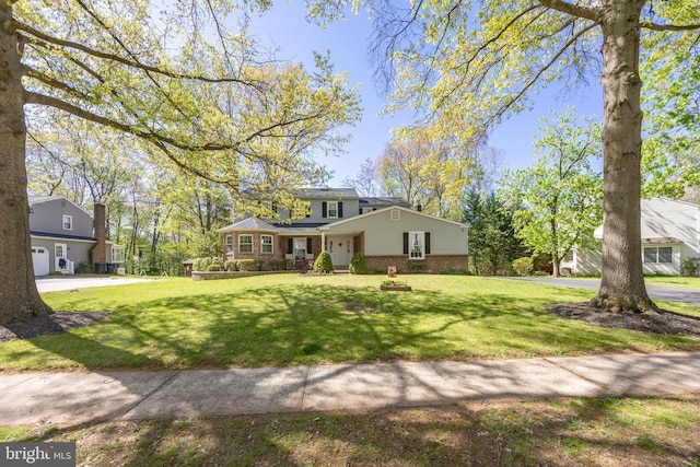 view of front of house with a front yard and brick siding